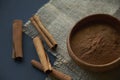 Cinnamon sticks, tied with jute rope in rustic style. Ground cinnamon in a wooden bowl and vintage scoop. Close up on a Royalty Free Stock Photo