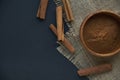 Cinnamon sticks, tied with jute rope in rustic style. Ground cinnamon in a wooden bowl and vintage scoop. Close up on a Royalty Free Stock Photo