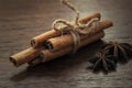 Cinnamon sticks tied by rope on wooden background