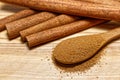 Cinnamon sticks and wooden spoon with cinnamon powder on wooden base Royalty Free Stock Photo