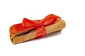 Cinnamon tied with a red ribbon, closeup on a white background Royalty Free Stock Photo