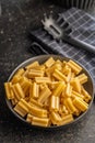 Cinque buchi. Uncooked italian pasta in bowl on black table Royalty Free Stock Photo