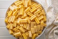 Cinque buchi. Uncooked italian pasta in bowl on white table. Top view Royalty Free Stock Photo