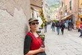 Focus on Female tourist looking at camera holding camera .with typical Italian village street background