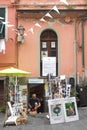 Cinque Terre, Italy - male artist works outside Artistartigianeria, a quaint local shop selling handmade jewelry as souvenirs.