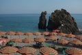 Cinque Terre, Italy - tourists relax under colorful beach parasols in Monterosso al Mare, along the Italian Riviera. Royalty Free Stock Photo