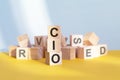 CIO written on wooden cubes, yellow background