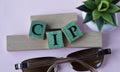 CIP - acronym on wooden cubes on the background of glasses and cactus