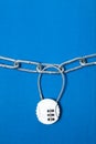 Cipher padlock on chain on blue background. Security concept.