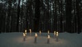 Circle of candles in dark winter forest