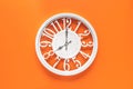 Circle clock on orange background wall