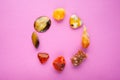 A circle of different minerals on pink background. Spiritual amber, calcite, Aragonite, Simbercite, Jasper, Tiger`s eye