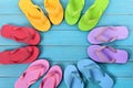 Circle of flip flops on blue painted beach decking, top view Royalty Free Stock Photo