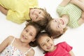 Circle of four young friends lying down smiling Royalty Free Stock Photo