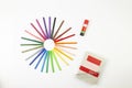 Circle made of felt-tip pens, a glue stick and a ruler on a book isolated on a white background Royalty Free Stock Photo