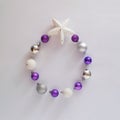 circle made od vivid violet, mettalic silver and snowy white baubles with star on top of it.copy space aesthetic