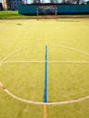 Circle in middle of court. Empty outdoor handball playground, plastic light green surface Royalty Free Stock Photo