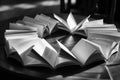 Circle of open books on a table bathed in sunlight. Pages create dynamic shadows, inviting exploration and knowledge. Royalty Free Stock Photo
