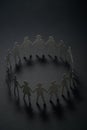 Circle of paper people holding hands on dark surface. Brotherhood, fraternity concept. Royalty Free Stock Photo