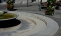 Circle shape fountain from which water flows. bowl with clear blue water waterfall on the square. flows through a decorative reces