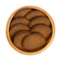Circle shaped pumpernickel slices, dark brown rye bread, in a wooden bowl