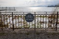 Circle sign of free bicycle parking attached to a metal fence at a lakeshore Royalty Free Stock Photo