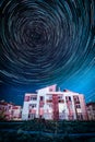 Circle star trails in the night sky above the houses Royalty Free Stock Photo