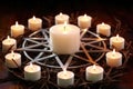 circle of white candles surrounding a silver pentacle