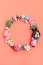 Circle wreath shape made of colorful spring flowers and eggs on pink background.  Easter celebration concept. Top view. Flat lay Royalty Free Stock Photo