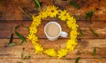 A Circle of yellow daisies on a wooden top with a mug of tea in the middle Royalty Free Stock Photo