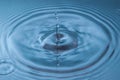 Circles on the blue surface of the water from the drop falling into it. Close-up Royalty Free Stock Photo