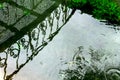 Circles from raindrops and reflection of openwork lattice bridge on the surface of the pond Royalty Free Stock Photo