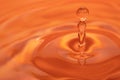 Circles on the water from a fallen drop of water. Orange, golden background. Royalty Free Stock Photo