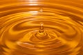 Circles on the water from a fallen drop of water. Yellow, golden background. Royalty Free Stock Photo