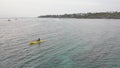 Drone footage of a female on a kayak in a lutos pose meditating in the ocean.