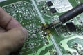 Electronic circuit board and soldering iron and hand working Royalty Free Stock Photo