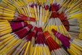 Circular arrangement pattern pile of bunches of red incense sticks and candles sets grouping by rubber band prepared in thai temp