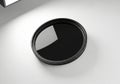 A circular black camera lens filter with a reflective surface isolated on white background Royalty Free Stock Photo