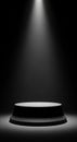 A circular, black pedestal is centered under a focused spotlight, casting a Royalty Free Stock Photo