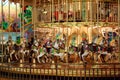 Circular children`s carousel with colorful horses and cars