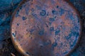 Circular Copper Plate on a Rough Surface in Deep Blue-Purple, and Red Tones. Royalty Free Stock Photo