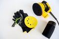 Circular electric power sander,disconnected container for dust.Work gloves,protection goggles,sandpaper disc on white Royalty Free Stock Photo