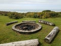 circular fire pit with charcoal and logs at beach