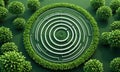circular garden with white spiral pattern is surrounded by lush green border, featuring variety trees and Royalty Free Stock Photo