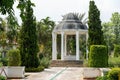 Circular gazebo in a garden surrounded by vegetation and trees