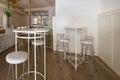 Circular high tables with matching white upholstered stools in a restaurant lounge