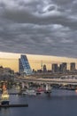 Circular highway leading to the Rainbow Bridge with Cargo and cruise ships moored in Odaiba Bay of Tokyo