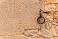Circular iron animal handler attached to a rustic stone facade Royalty Free Stock Photo
