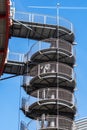 Circular iron staircase for fire escape outside a modern metal industrial building fence in the open air Royalty Free Stock Photo