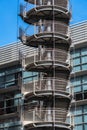 Circular iron staircase for fire escape outside a modern metal industrial building fence in the open air Royalty Free Stock Photo